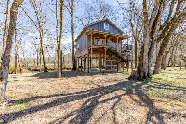 view of front of property featuring a porch, stairway, board and batten siding, a carport, and driveway