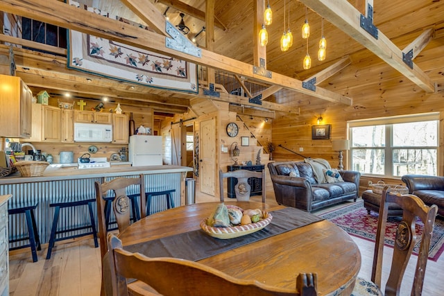 dining area with beam ceiling, wooden walls, high vaulted ceiling, light wood-type flooring, and wooden ceiling