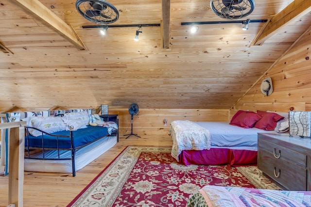 bedroom featuring vaulted ceiling with beams, wood walls, wood finished floors, wood ceiling, and track lighting