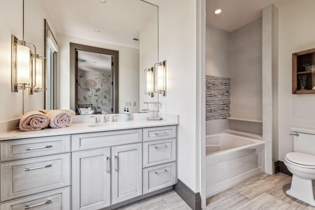 full bathroom featuring toilet, vanity, ensuite bath, a tub, and baseboards