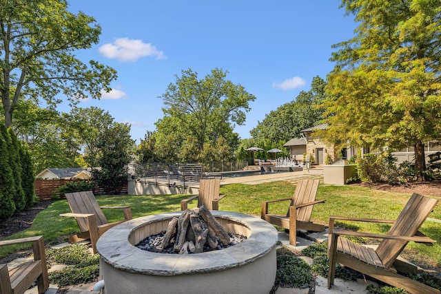 view of yard with a fire pit, a patio area, and fence