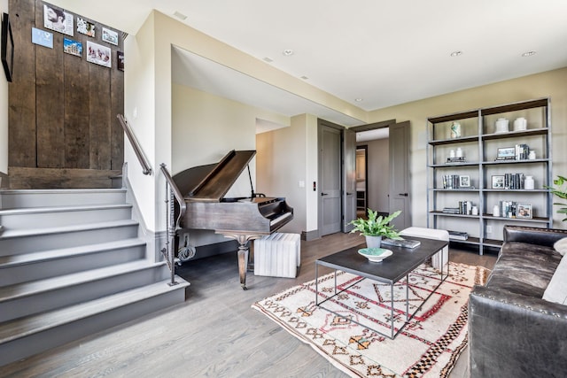 living room featuring stairs, baseboards, and wood finished floors