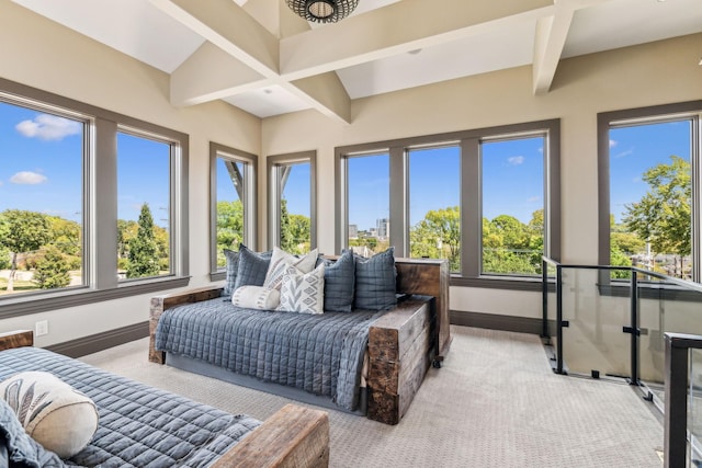 bedroom with beam ceiling, multiple windows, and baseboards