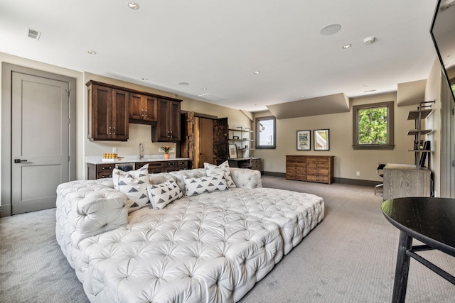 living room with baseboards, a healthy amount of sunlight, visible vents, and light colored carpet