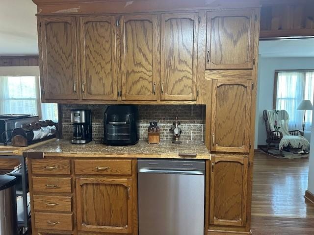 kitchen featuring stainless steel dishwasher, dark wood-type flooring, brown cabinets, and tasteful backsplash