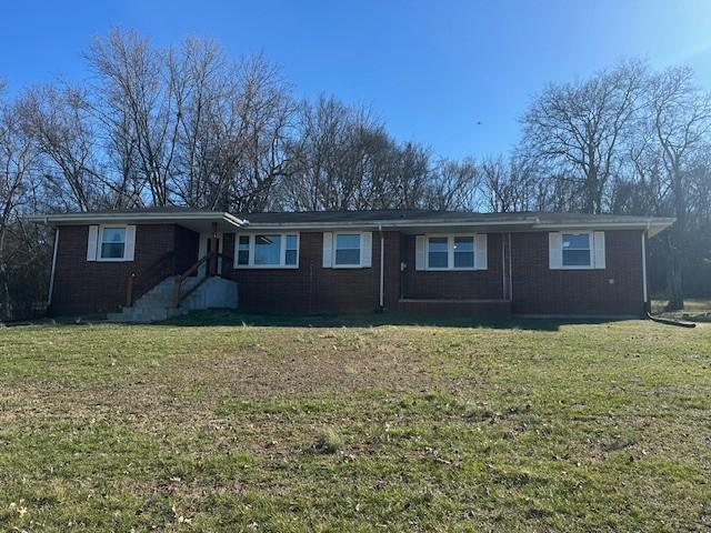 single story home featuring a front lawn