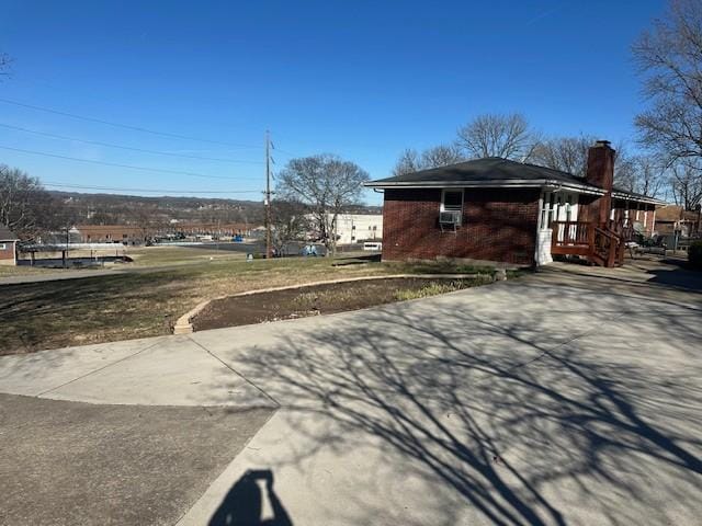 view of side of property featuring a chimney and brick siding