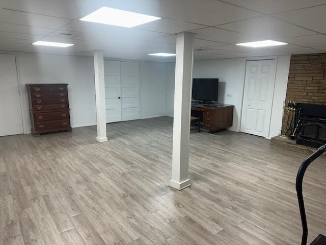 finished below grade area featuring a drop ceiling and wood finished floors