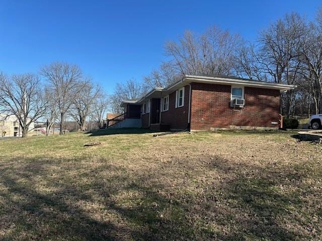 view of property exterior with brick siding and a yard