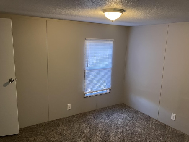 carpeted spare room with a textured ceiling