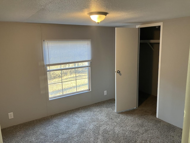 unfurnished bedroom with a closet, a textured ceiling, and carpet flooring