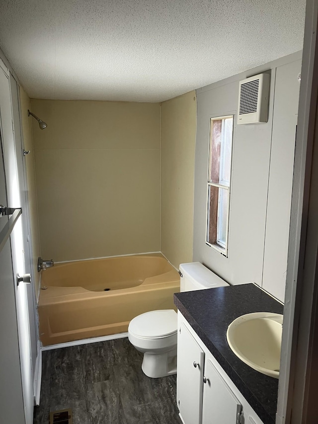 full bathroom with shower / bath combination, toilet, wood finished floors, a textured ceiling, and vanity