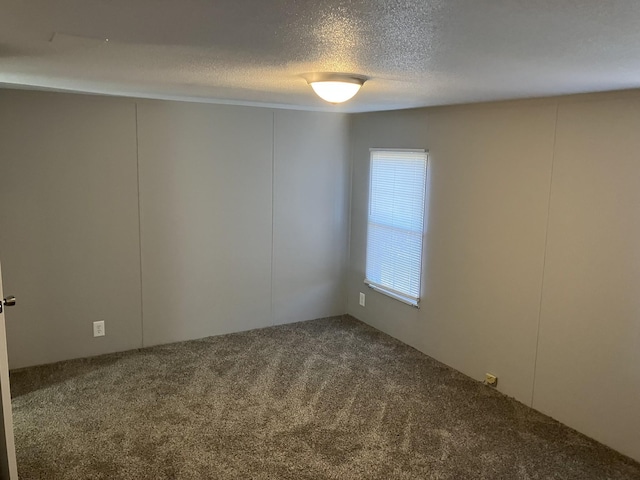 carpeted spare room with a textured ceiling