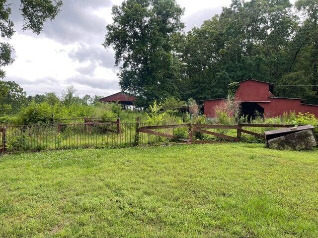 view of yard featuring an outbuilding, a barn, and fence