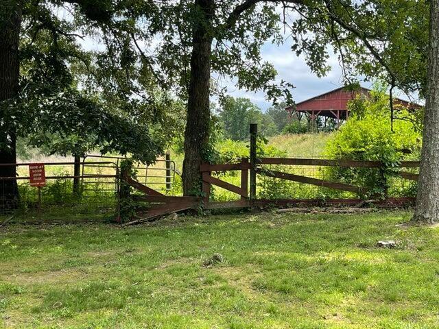 view of gate featuring fence and a lawn