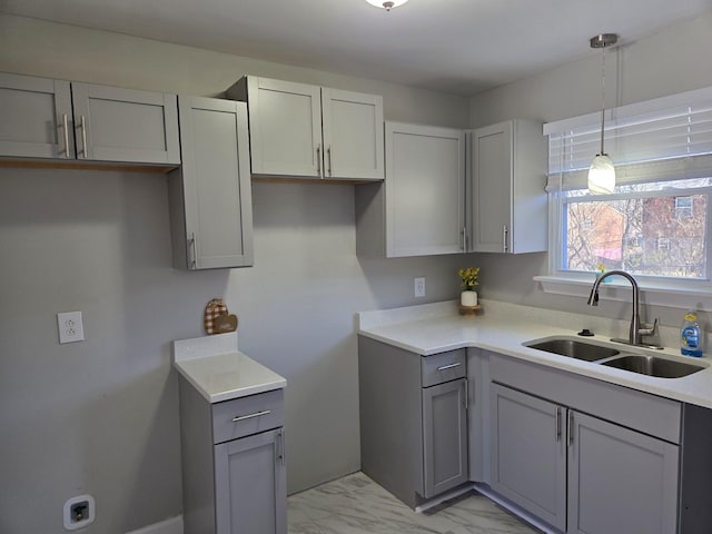 kitchen featuring gray cabinets, a sink, and marble finish floor