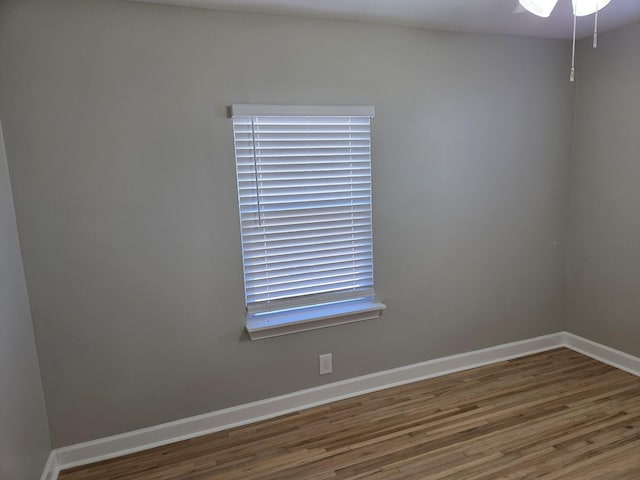 spare room featuring wood finished floors and baseboards