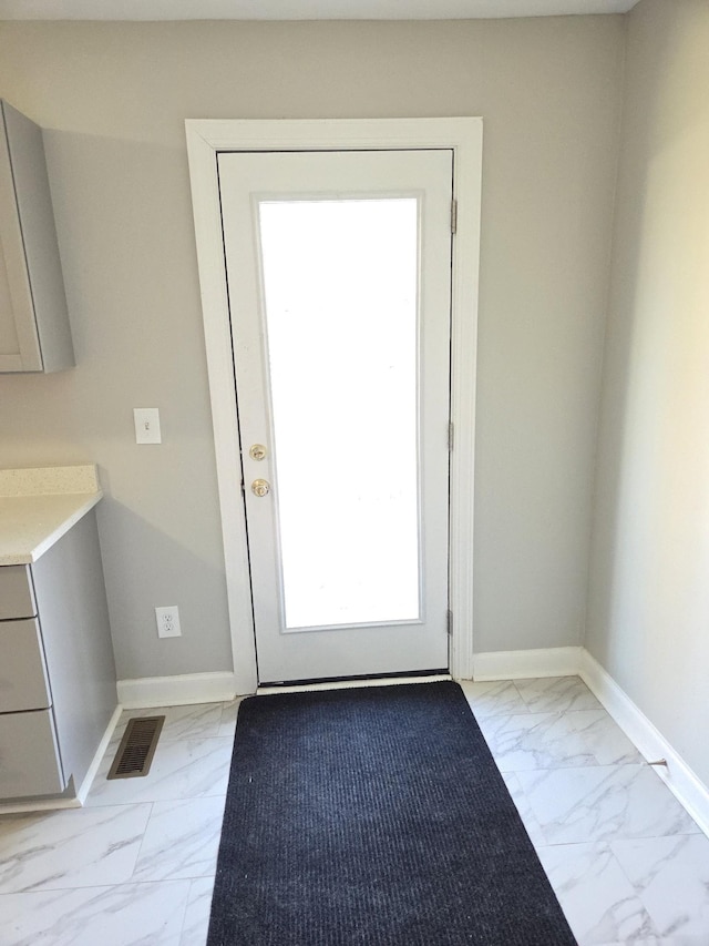 entryway with marble finish floor, baseboards, and visible vents