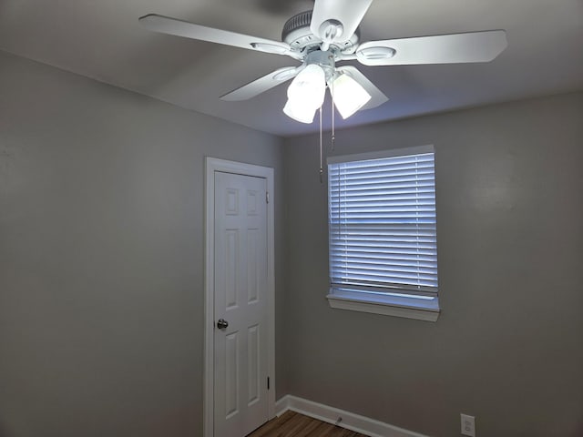 unfurnished room with ceiling fan, wood finished floors, and baseboards