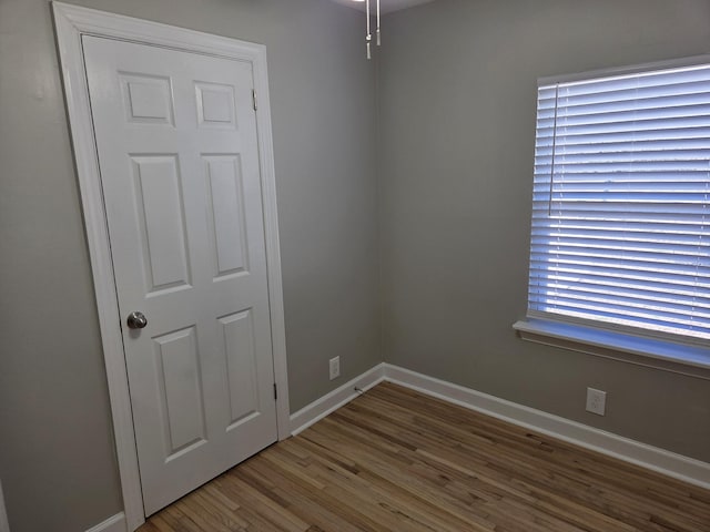 spare room featuring baseboards and wood finished floors