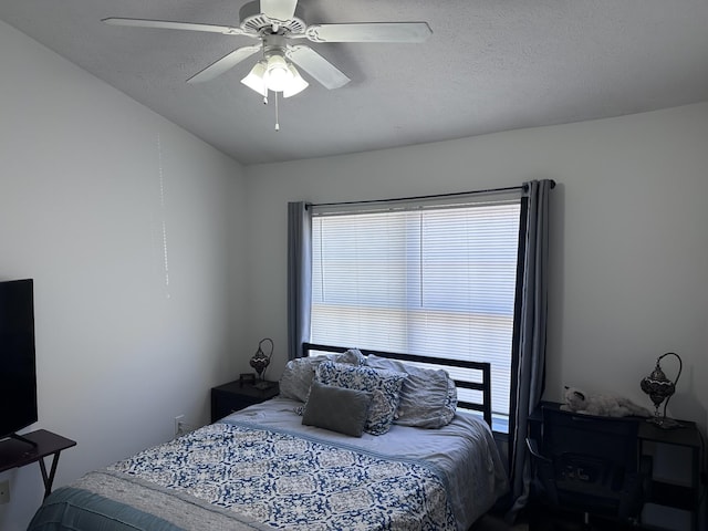 bedroom with ceiling fan and a textured ceiling