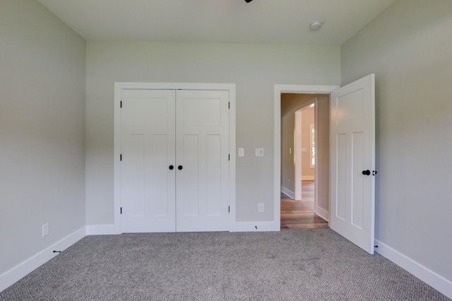 unfurnished bedroom with carpet, baseboards, and a closet