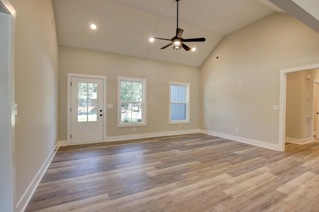 interior space featuring high vaulted ceiling, wood finished floors, a ceiling fan, and baseboards