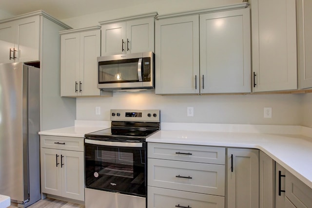 kitchen featuring appliances with stainless steel finishes, light countertops, and gray cabinetry