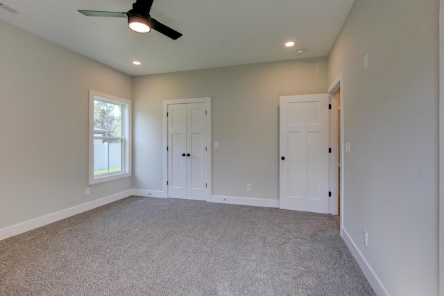 unfurnished bedroom with baseboards, dark colored carpet, and recessed lighting