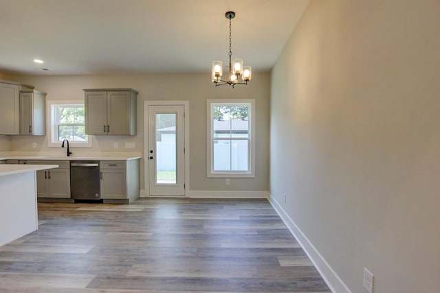 kitchen featuring pendant lighting, gray cabinets, light countertops, dishwasher, and baseboards