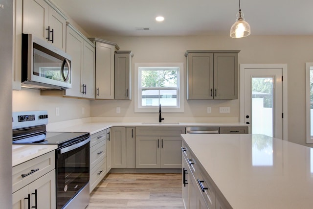 kitchen with a sink, visible vents, light countertops, appliances with stainless steel finishes, and gray cabinets