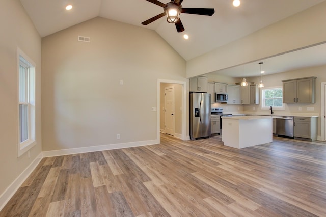 kitchen featuring a center island, stainless steel appliances, light countertops, visible vents, and light wood-style floors