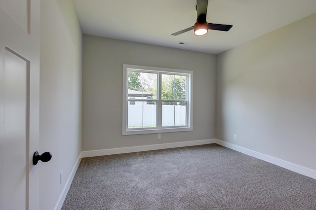 empty room featuring carpet flooring, ceiling fan, visible vents, and baseboards