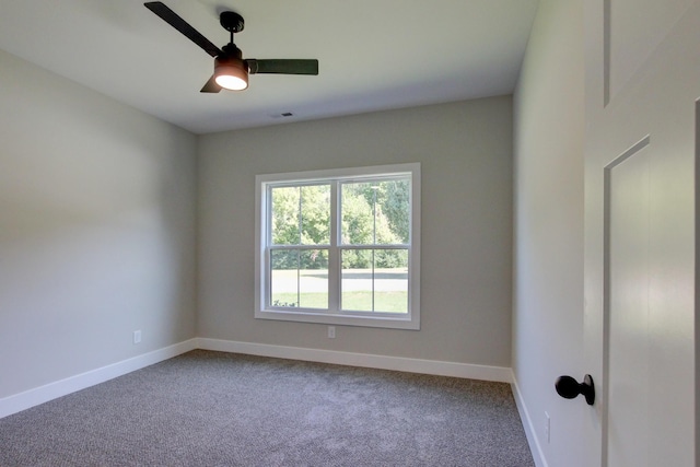 carpeted spare room with visible vents, ceiling fan, and baseboards