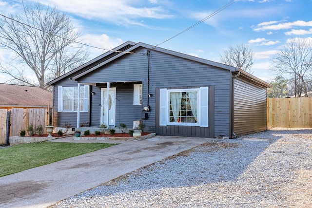 view of front facade featuring gravel driveway and fence