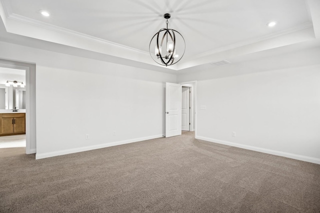 carpeted spare room featuring baseboards, a tray ceiling, and crown molding