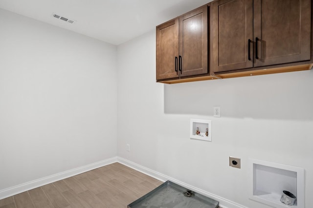 laundry room featuring hookup for a washing machine, cabinet space, visible vents, hookup for an electric dryer, and baseboards