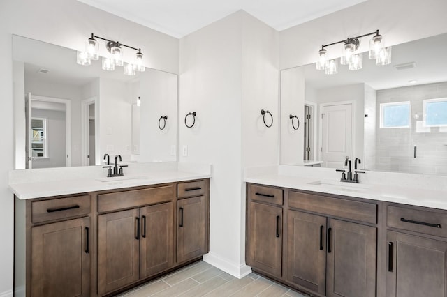 bathroom featuring two vanities, a sink, and tiled shower