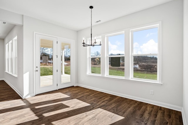 unfurnished dining area featuring baseboards, visible vents, and dark wood-type flooring