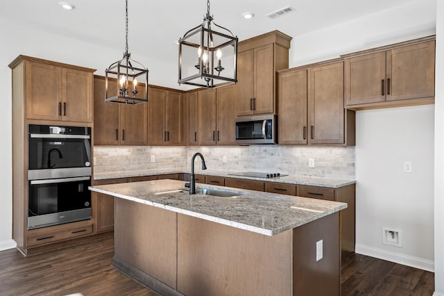 kitchen with visible vents, appliances with stainless steel finishes, dark wood-type flooring, and a sink