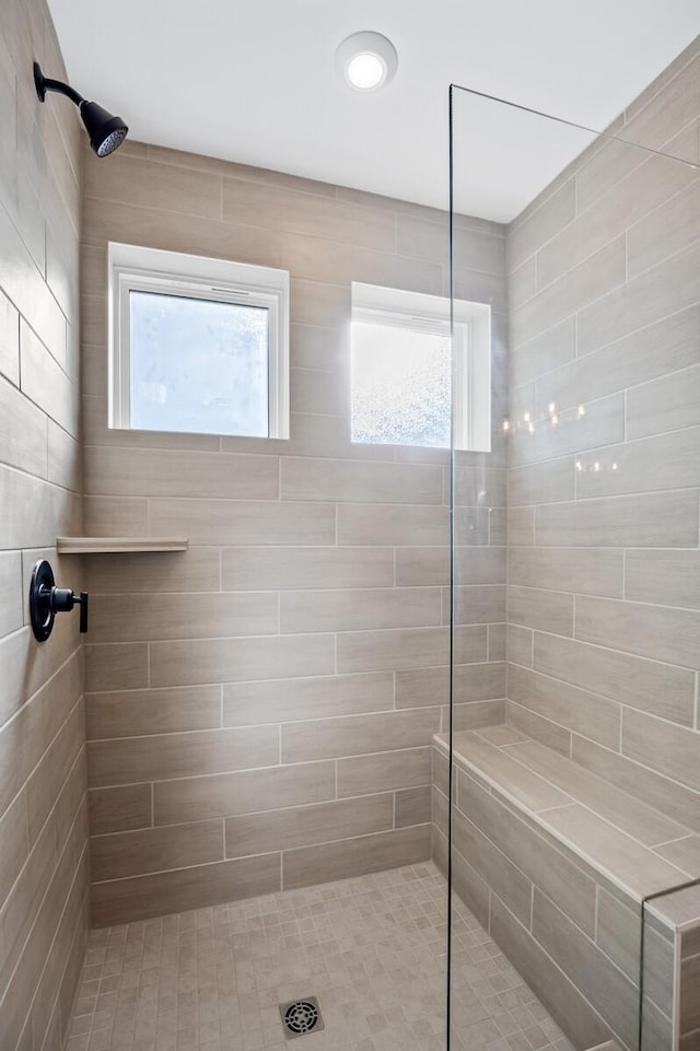 bathroom with a healthy amount of sunlight and a tile shower