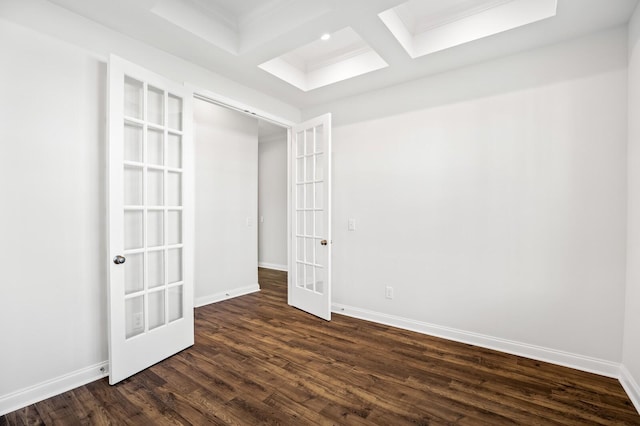 empty room with baseboards, coffered ceiling, dark wood finished floors, french doors, and beam ceiling