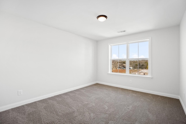 carpeted spare room featuring visible vents and baseboards