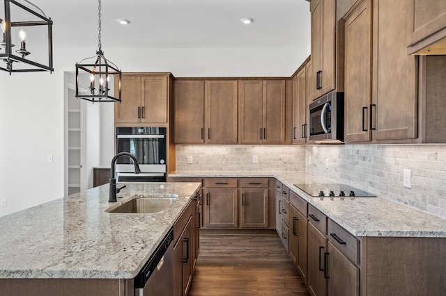 kitchen featuring tasteful backsplash, light stone counters, appliances with stainless steel finishes, dark wood-style flooring, and a sink