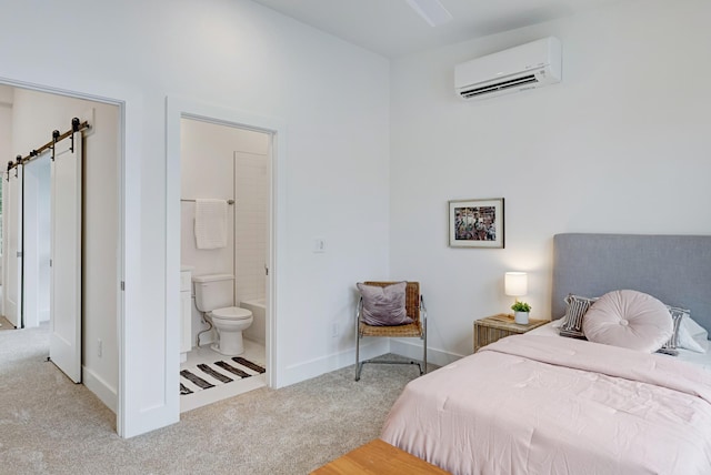 carpeted bedroom featuring a wall mounted air conditioner, ensuite bath, and baseboards