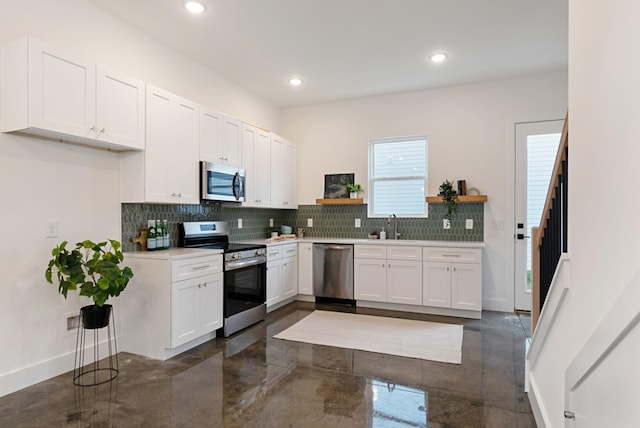 kitchen with open shelves, tasteful backsplash, white cabinetry, and stainless steel appliances