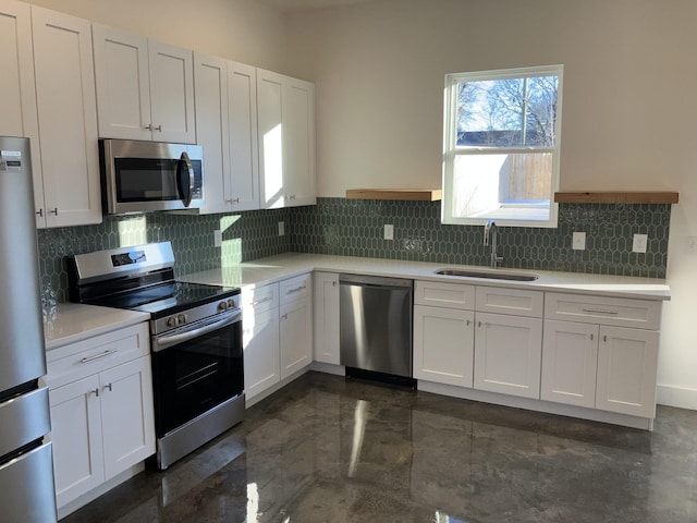 kitchen with stainless steel appliances, light countertops, decorative backsplash, white cabinets, and a sink