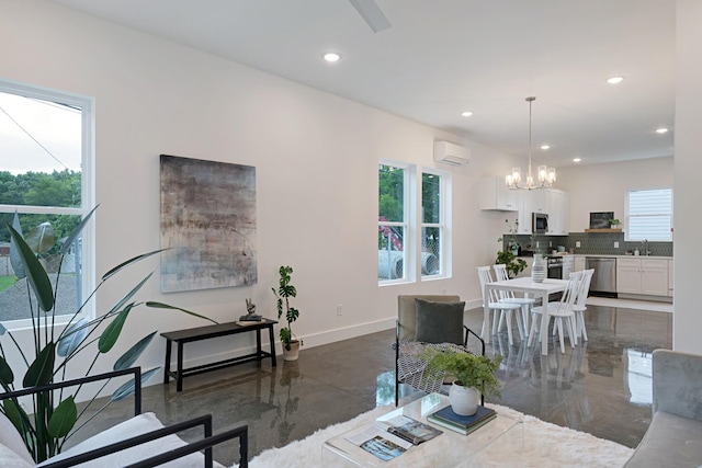 living room with a notable chandelier, baseboards, a wealth of natural light, and a wall mounted AC