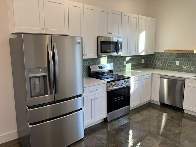 kitchen with stainless steel appliances, light countertops, backsplash, and white cabinetry