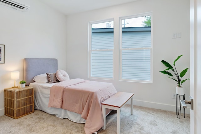 bedroom with a wall unit AC, carpet flooring, and baseboards